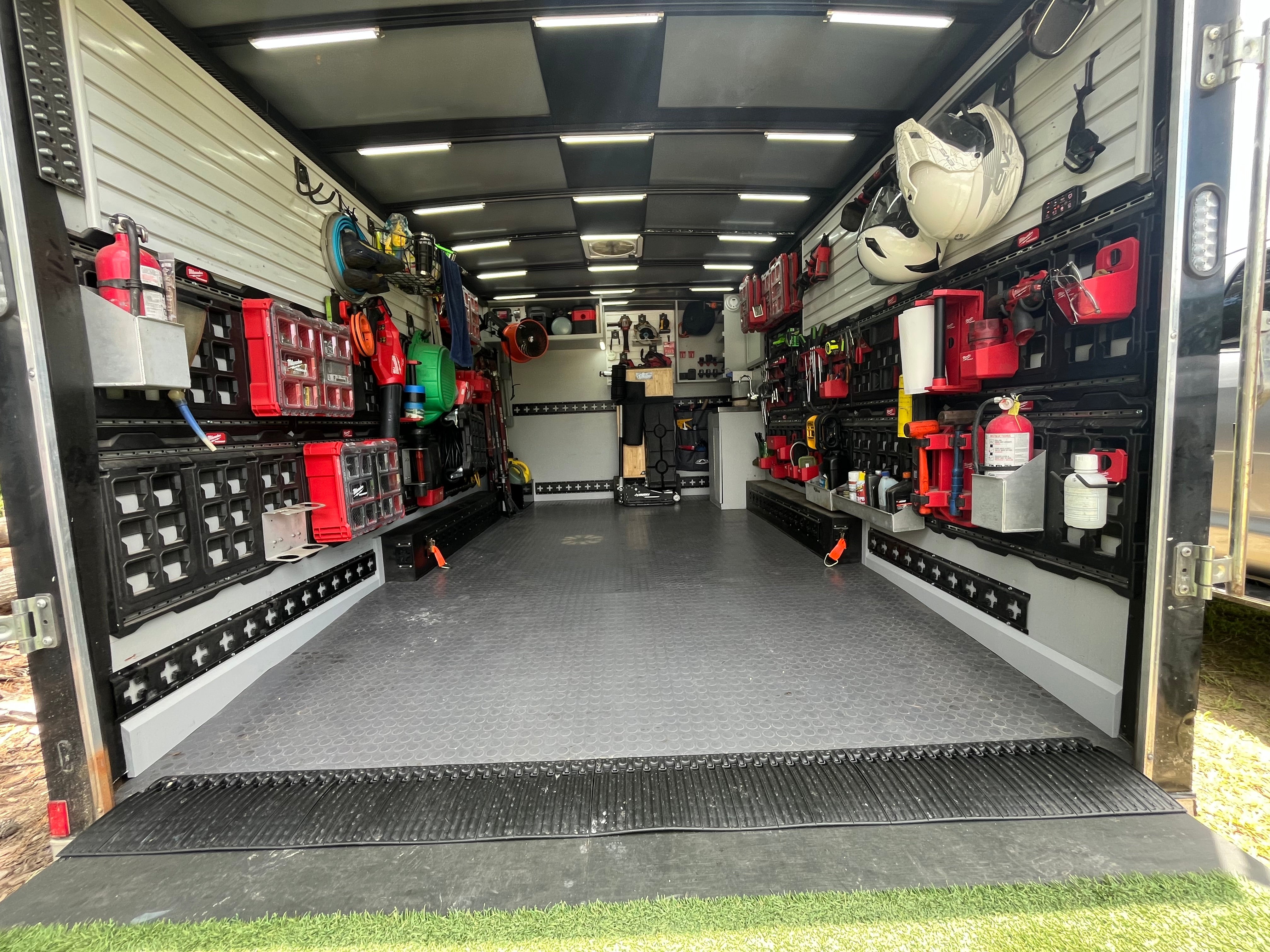 Trailer interior with organized tools and equipment on shelves and walls.